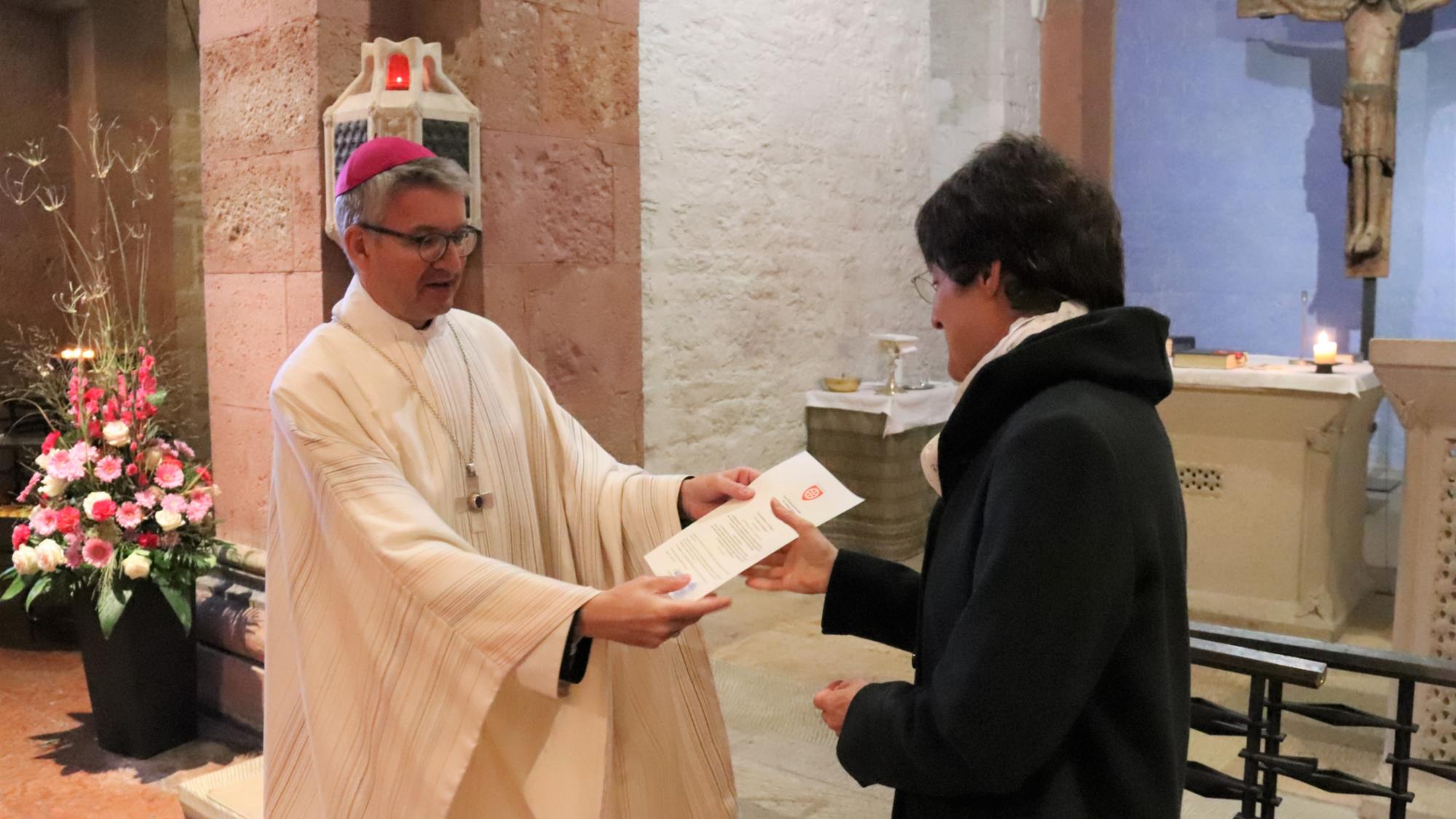Bischof Peter Kohlgraf überreicht Dr. Juliane Reus ihr Dekret für ihre neue Aufgabe als Referentin am Institut für Spiritualität