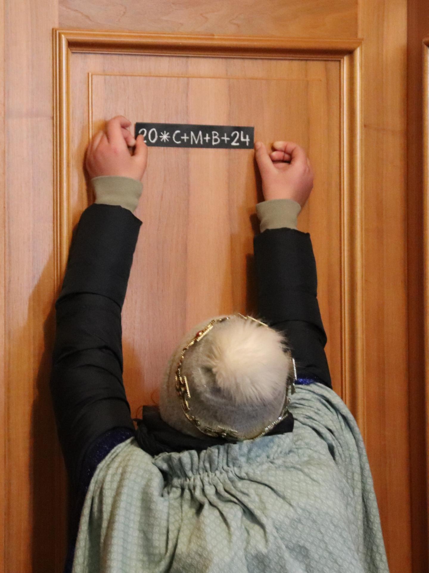 Eine Sternsingerin brachte den Segen an der Tür an (c) Bistum Mainz/Hoffmann