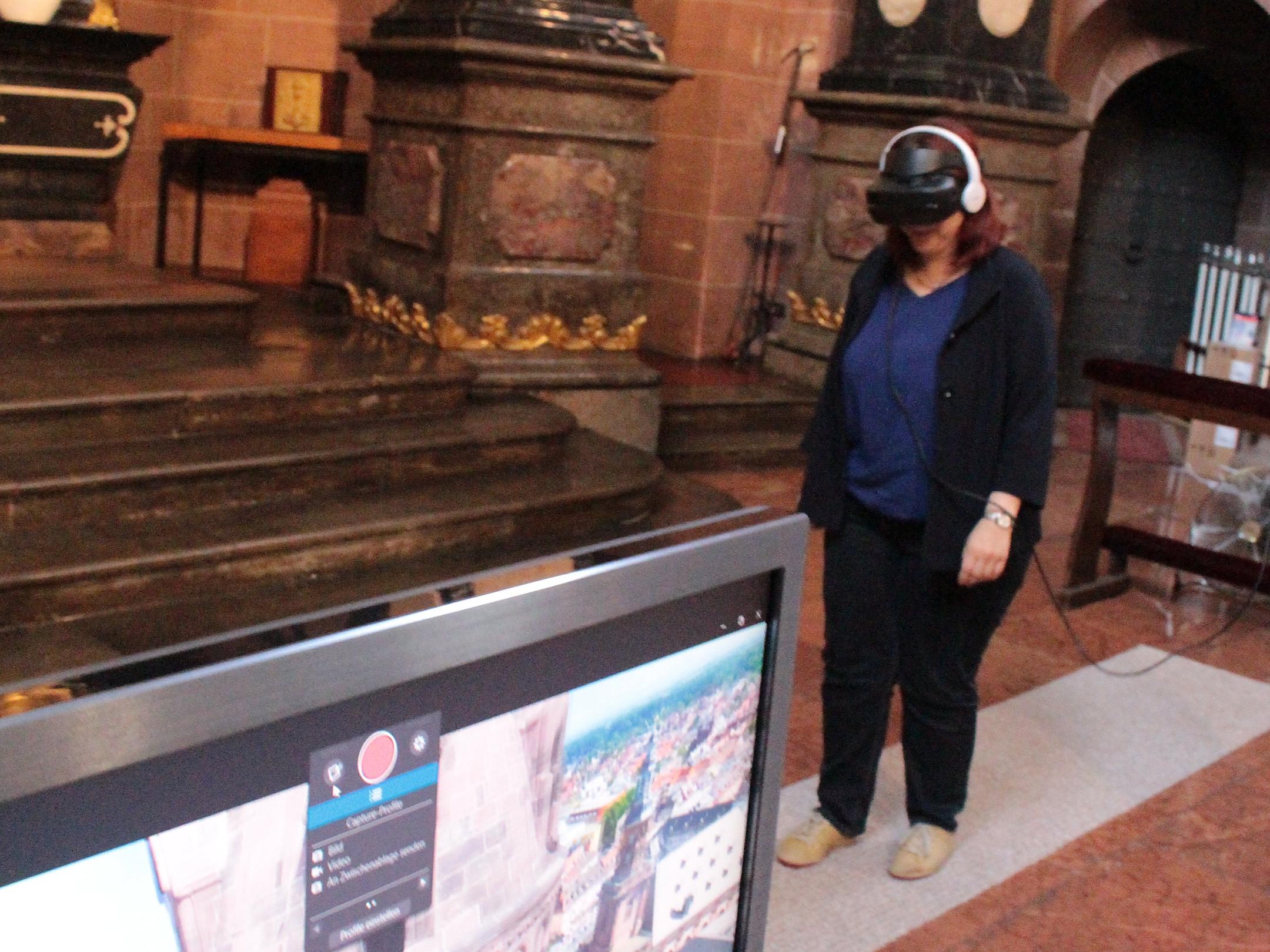Worms, 29. Mai 2018: Eine Journalistin probiert beim Pressetermin im Ostchor das Virtual Reality-Projekt „Balancieren zwischen den Dom-Türmen“; auf dem Monitor ist ihre Aussicht zu sehen.