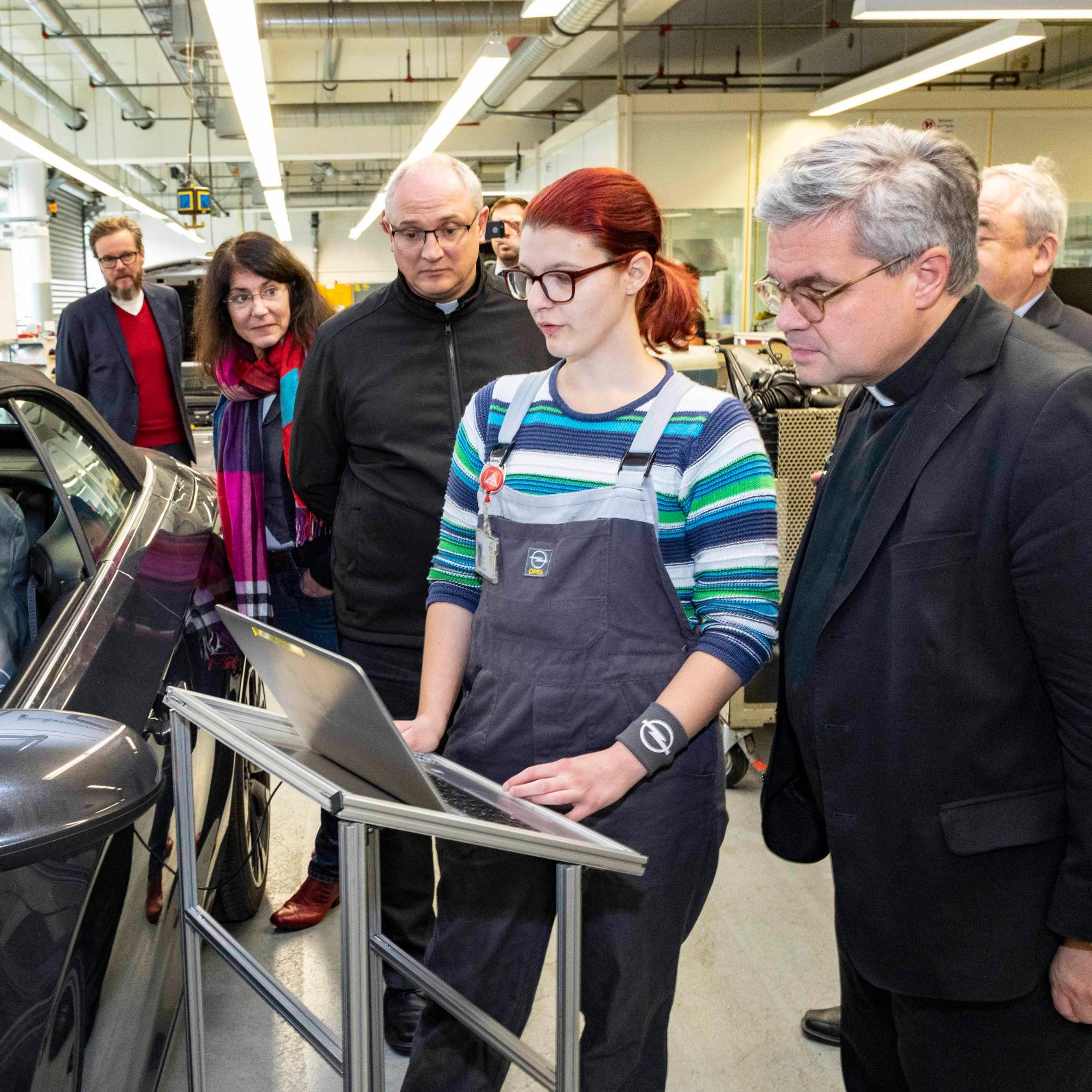 Rüsselsheim, 21.11.2019: Weihbischof Udo Markus Bentz (r.) im Opel-Ausbildungszentrum im Gespräch mit Lena Heck (2.v.r.), die eine Ausbildung zur Kraftfahrzeugmechatronikerin absolviert.