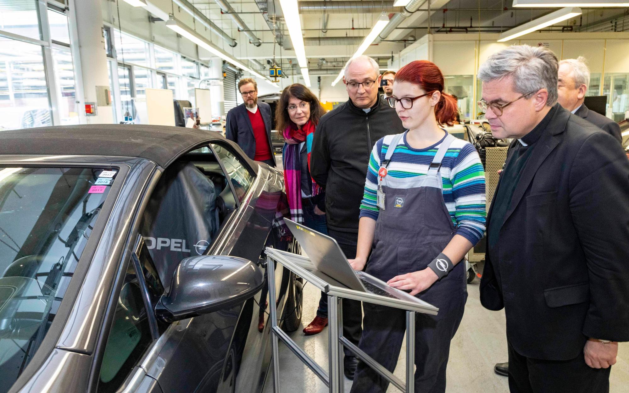 Rüsselsheim, 21.11.2019: Weihbischof Udo Markus Bentz (r.) im Opel-Ausbildungszentrum im Gespräch mit Lena Heck (2.v.r.), die eine Ausbildung zur Kraftfahrzeugmechatronikerin absolviert. (c) Opel