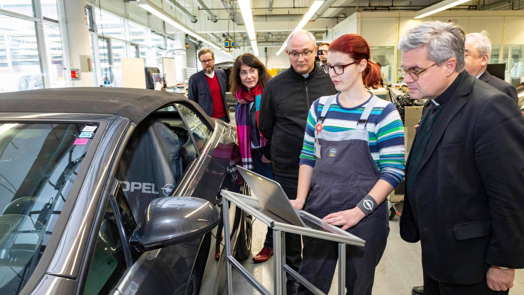 Rüsselsheim, 21.11.2019: Weihbischof Udo Markus Bentz (r.) im Opel-Ausbildungszentrum im Gespräch mit Lena Heck (2.v.r.), die eine Ausbildung zur Kraftfahrzeugmechatronikerin absolviert.