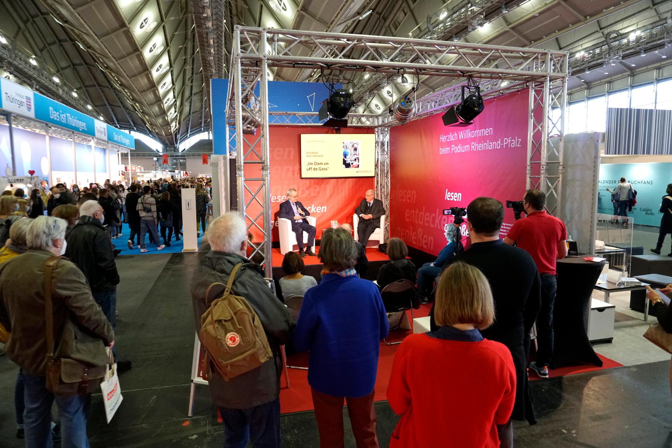Domdekan Heinz Heckwolf (r.) präsentiert mit Verleger Matthias Ess (links) das neu erschienene Buch „Im Dom un uff de Gass“ auf der Frankfurter Buchmesse.