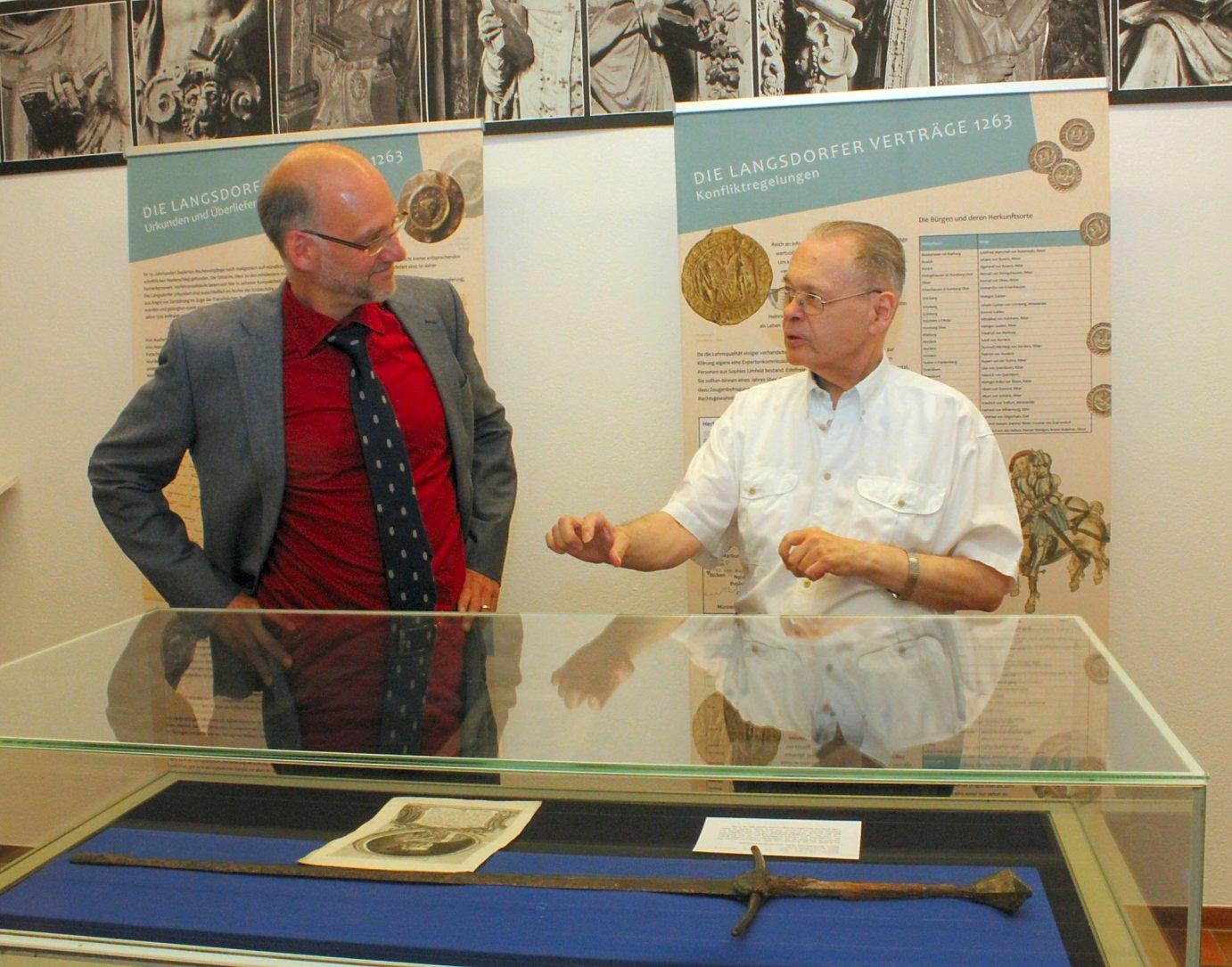 Mainz, 2.7.2014: Dr. Helmut Hinkel (r.) zeigt Prof. Dr. Ulrich Ritzerfeld die Exponate der Ausstellung in der Mainzer Martinus-Bibliothek.