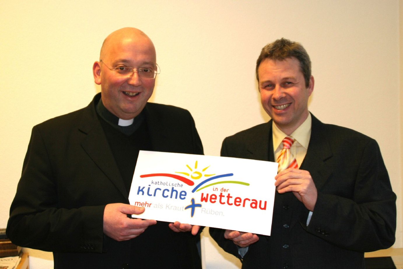 Butzbach, 20.12.2006: Pfarrer Hans-Joachim Wahl (l.), Dekan des Dekanates Wetterau-West, und Gregor Rettinghaus, Leiter der Projektgruppe der katholischen Kirche beim Hessentag 2007, stellen das Logo des Dekanates Wetterau-West für den Hessentag vor. (c) (MBN)