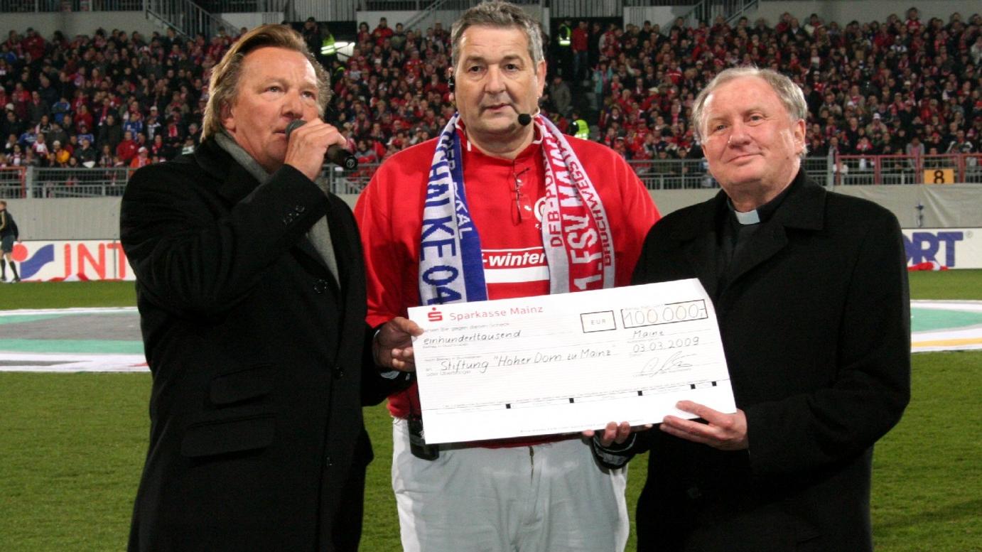 Mainz, 3.3.2009: Scheckübergabe im Mainzer Bruchwegstadion mit (v.l.) Mainz 05-Präsident Harald Strutz, Stadionsprecher Klaus Hafner und Generalvikar Dietmar Giebelmann.