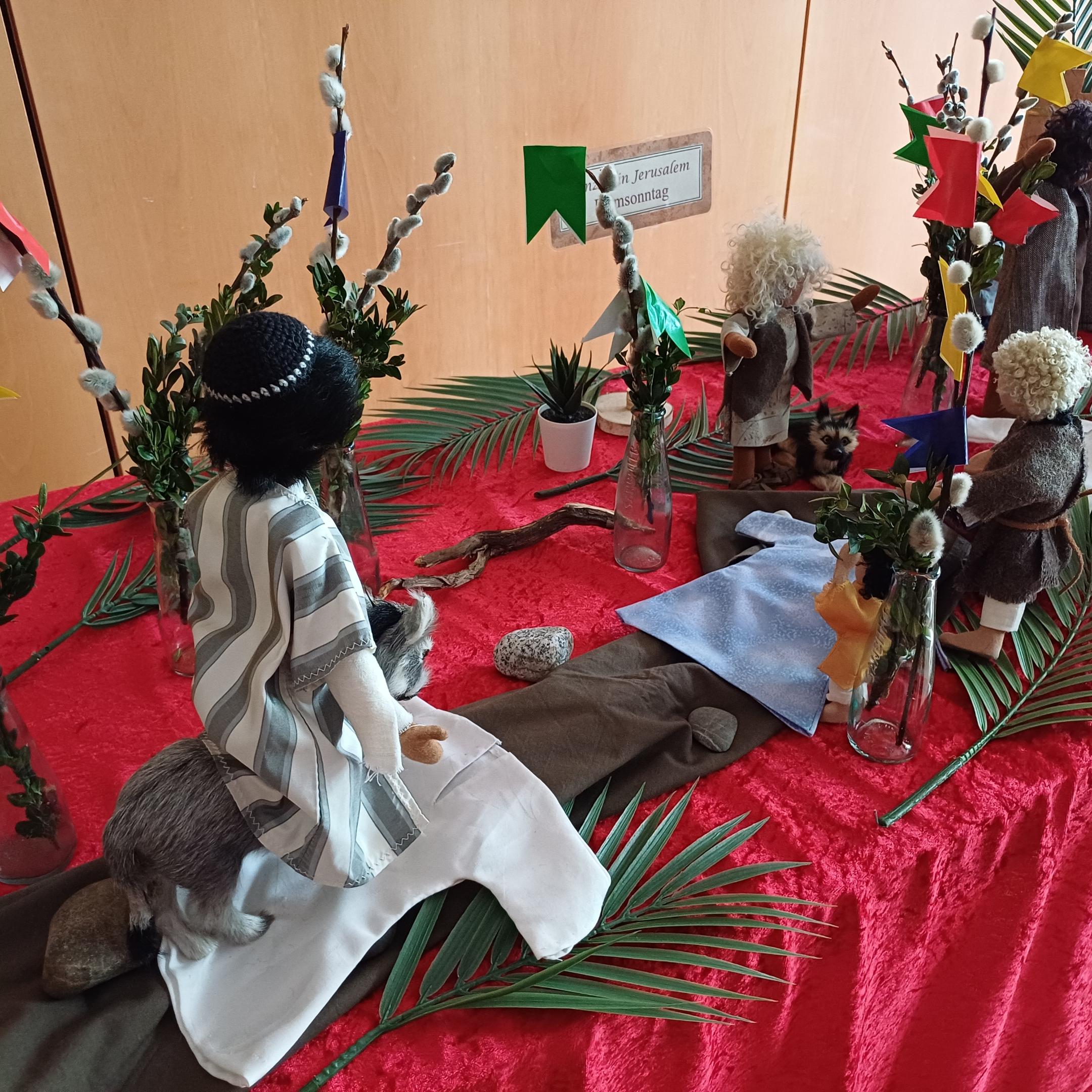 Mit biblischen Erzählfiguren ist der Einzug Jesu nach Jerusalem dargestellt