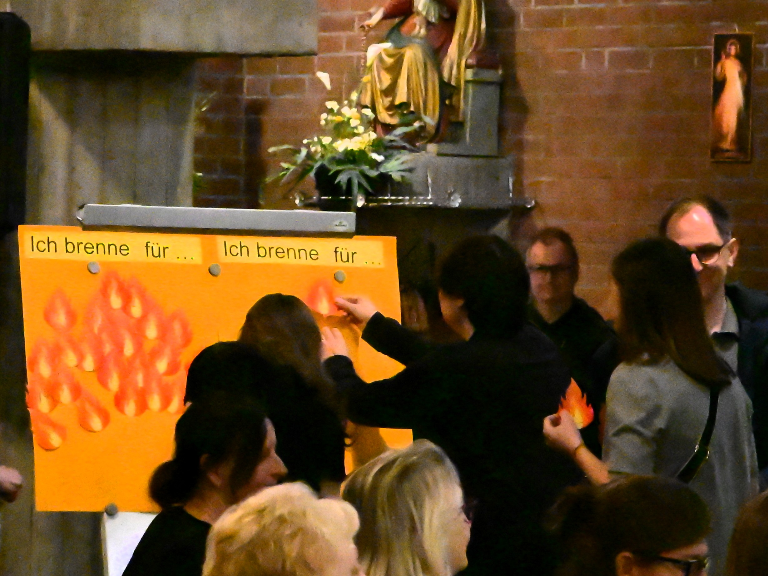Firmlinge heften Papierflammen auf eine Tafel
