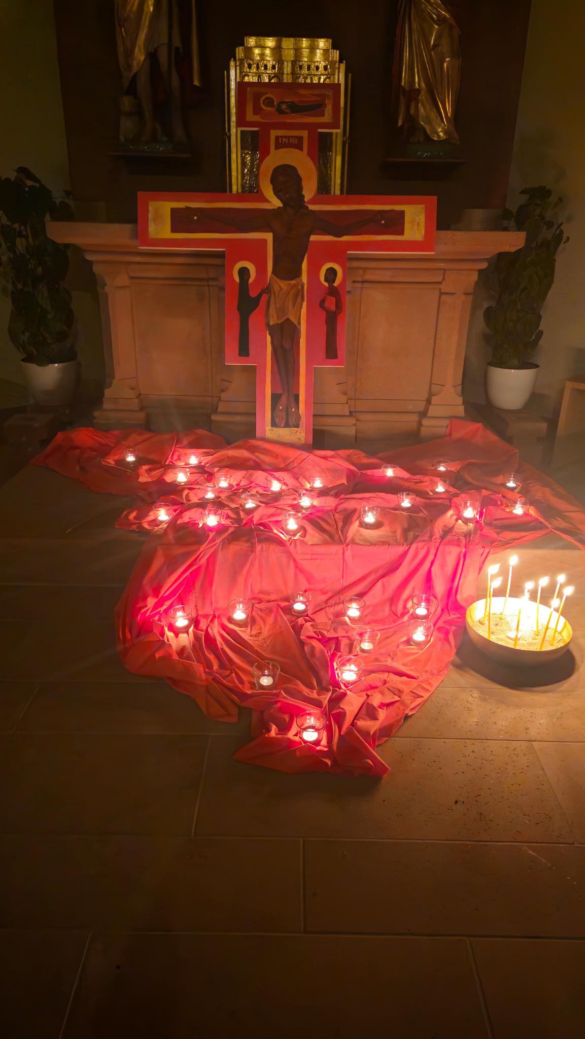 Ein Kreuz wie es in Taize zu finden ist mit vielen Kerzen davor