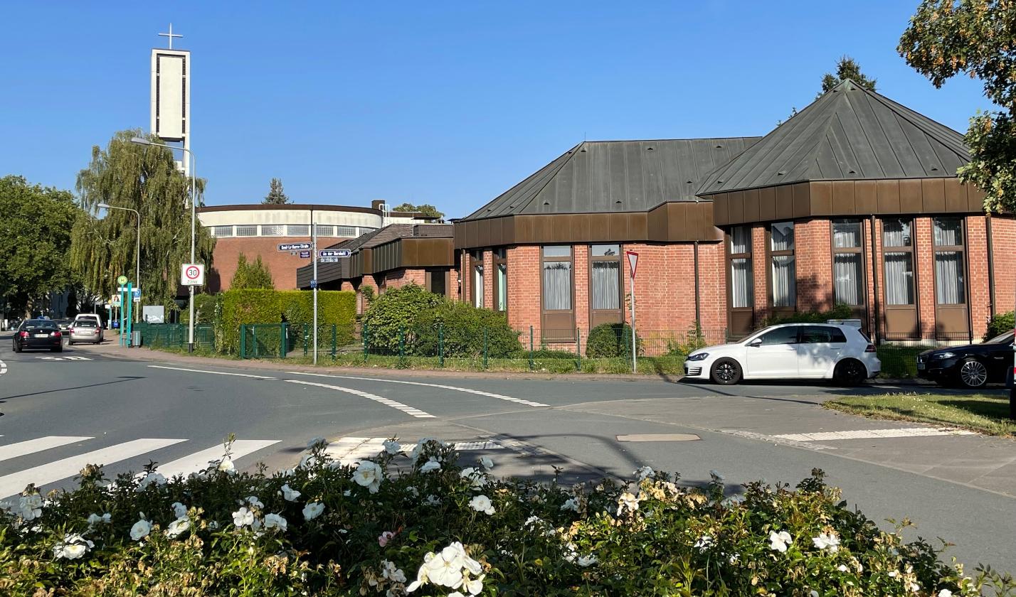 Blick auf Kirche und Pfarrgemeindehaus in Nieder-Eschbach, Blumen im Vordergrund