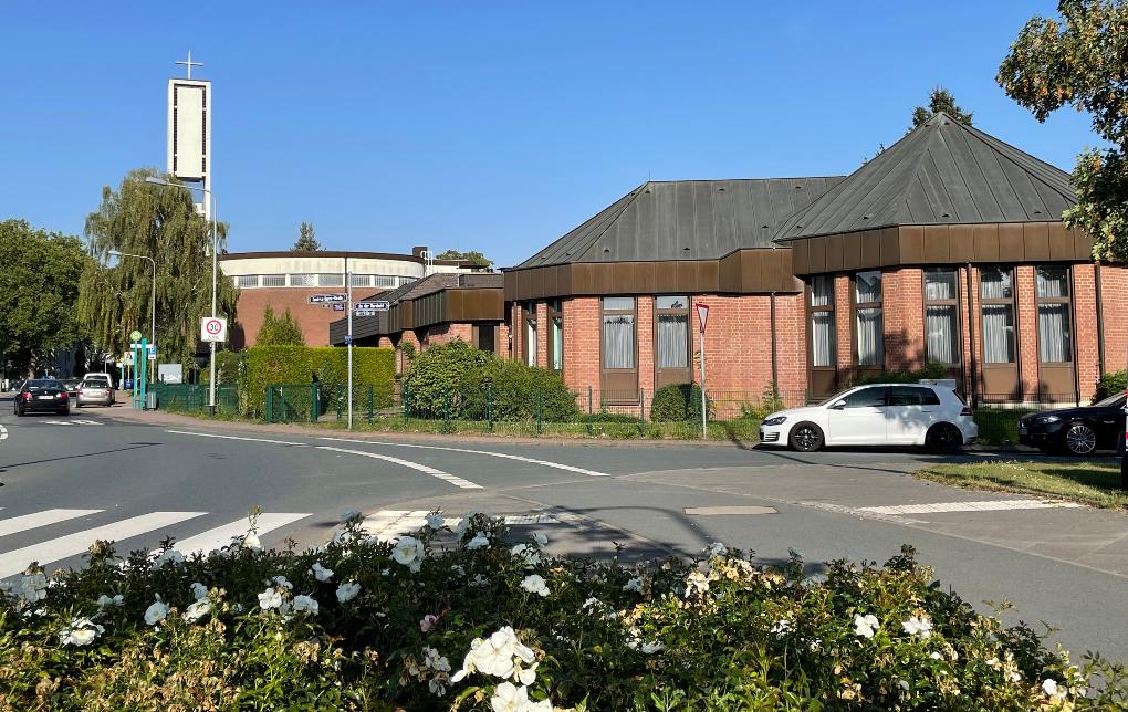 Blick auf Kirche und Pfarrgemeindehaus in Nieder-Eschbach, Blumen im Vordergrund
