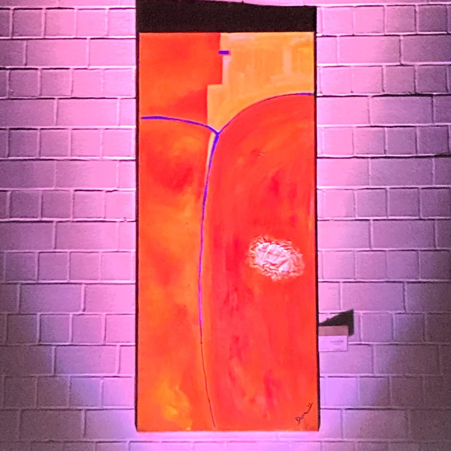 großformatige Malerei in Orange, auf einer weißen Backsteinwand, blaue Linien als Tau-Kreuz