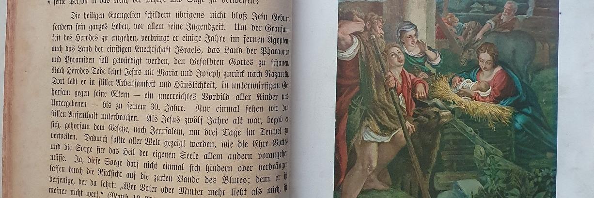 Aufgeschlagene Bibel, auf einer Seite Text, auf der anderen Seite ein Bild einer Krippenszene.