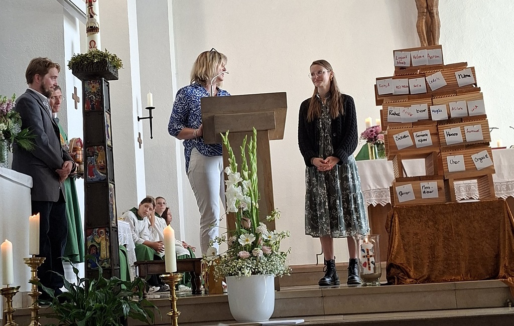 Menschen stehen im Altarraum einer Kirche und begrüßen eine neue Pastoralreferentin.