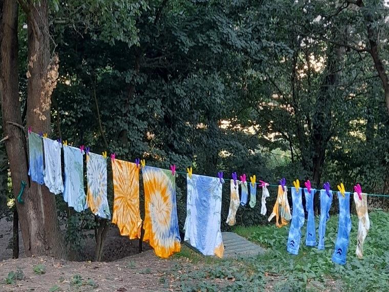 Gebatikte T-Shirts hängen auf einer Wäscheleine zum Trocknen.