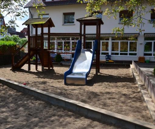 Spielplatz des Montessori-Kinderhauses mit Rutsche und Klettergerüst