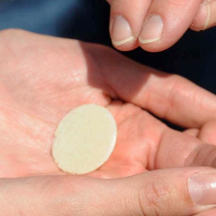 Eine Hostie wird in eine Hand gelegt.