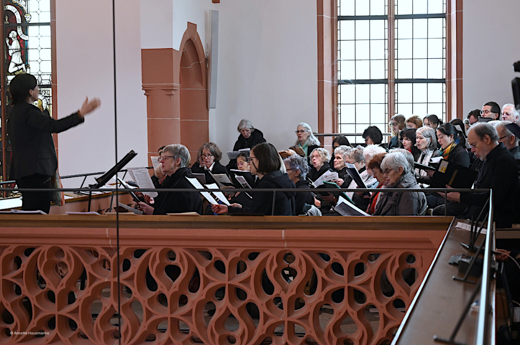 Dirigentin und Chorsänger*innen während des Gottesdienstes