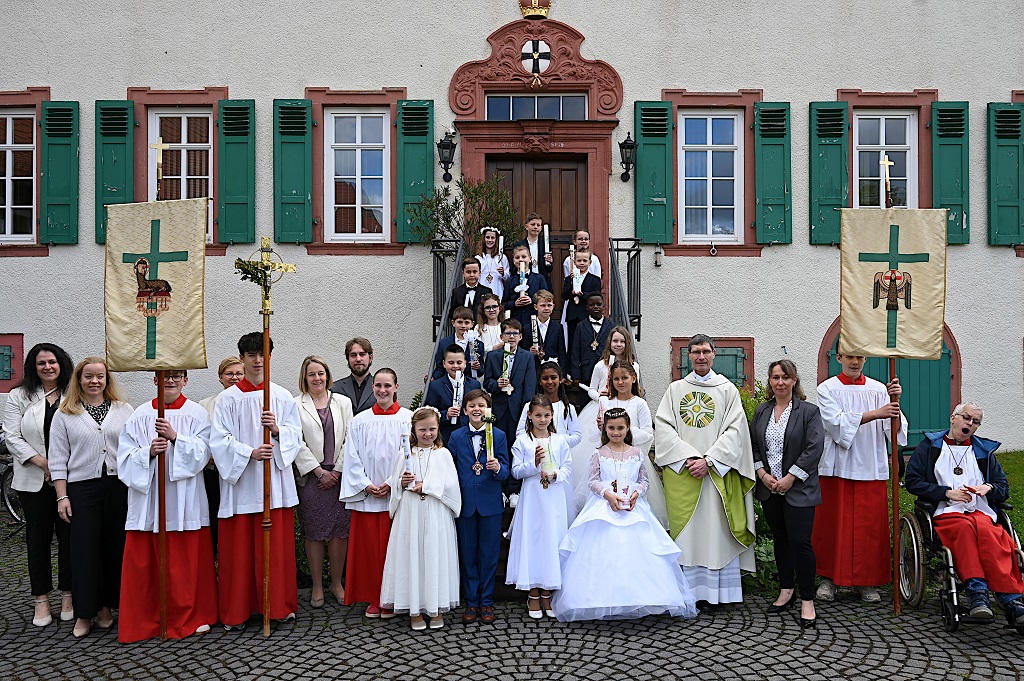 Die Kommunionkinder aus Ober- und Nieder-Mörlen, aus Butzbach und Rockenberg nach dem Festgottesdienst in St. Remigius mit Pfarrer Roßbach, den Katechetinnen, Gemeindereferent und Messdienern