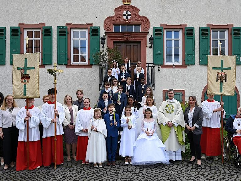 Die Kommunionkinder aus Ober- und Nieder-Mörlen, aus Butzbach und Rockenberg nach dem Festgottesdienst in St. Remigius mit Pfarrer Roßbach, den Katechetinnen, Gemeindereferent und Messdienern