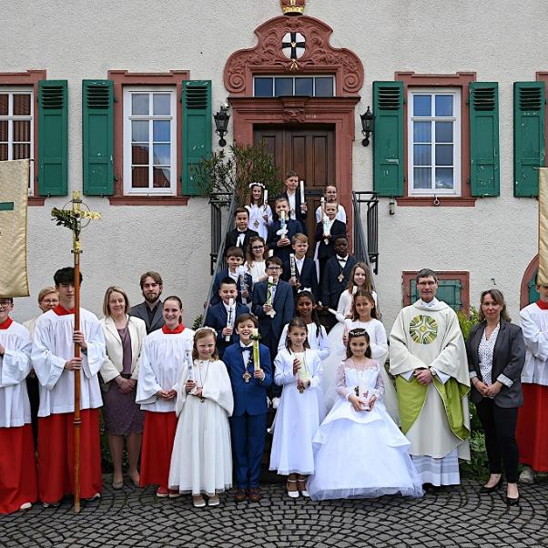 Die Kommunionkinder aus Ober- und Nieder-Mörlen, aus Butzbach und Rockenberg nach dem Festgottesdienst in St. Remigius mit Pfarrer Roßbach, den Katechetinnen, Gemeindereferent und Messdienern