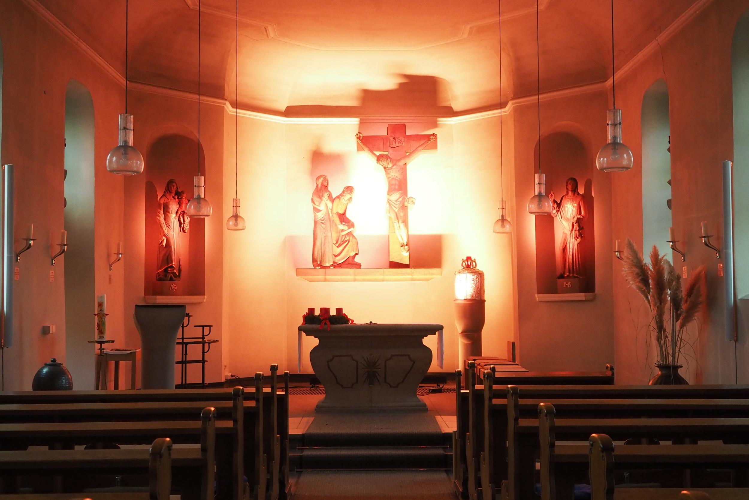 Blick in den gesamten Kirchraum, Altarraum in helles Licht getaucht.