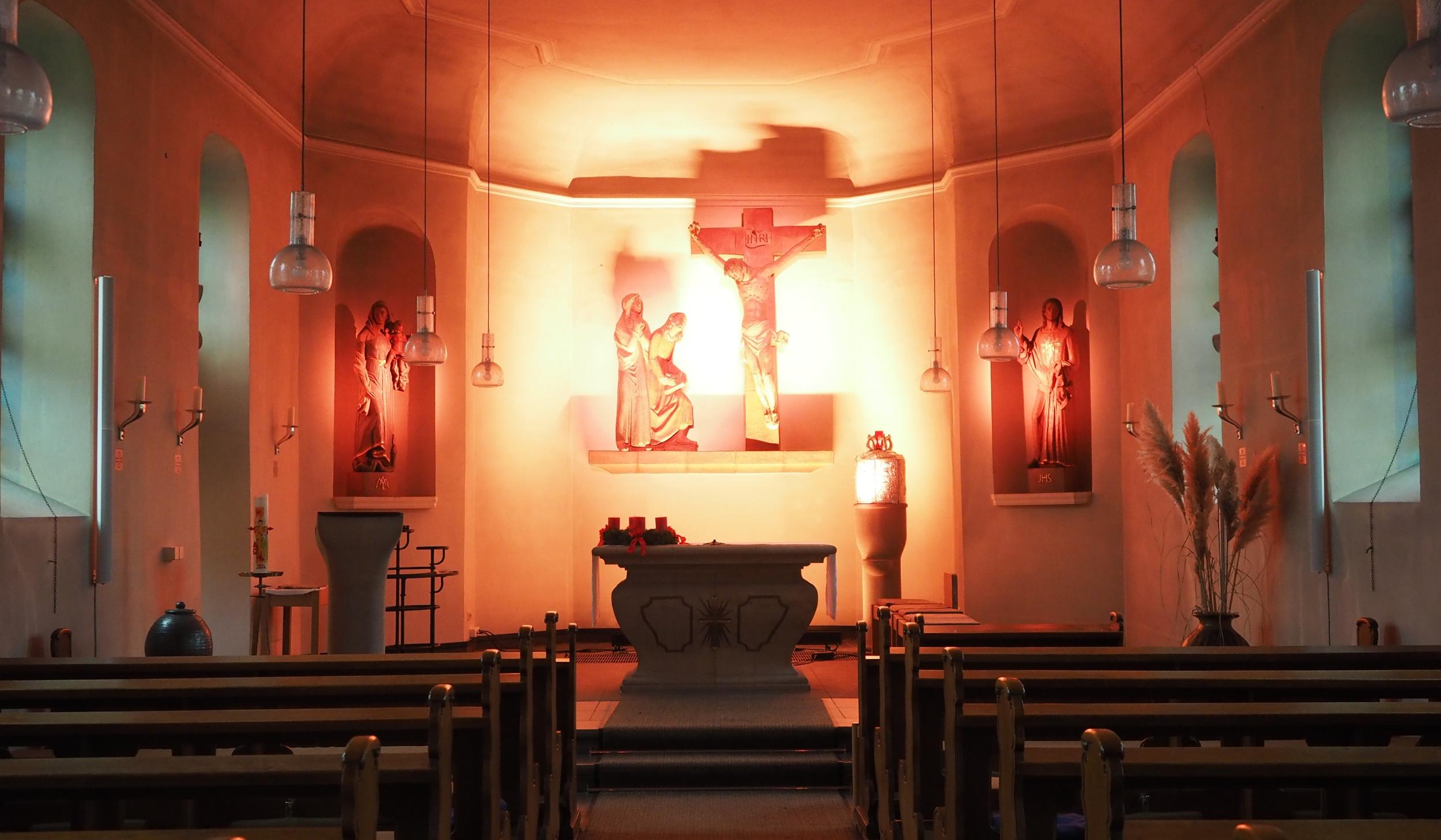 Blick in den gesamten Kirchraum, Altarraum in helles Licht getaucht.