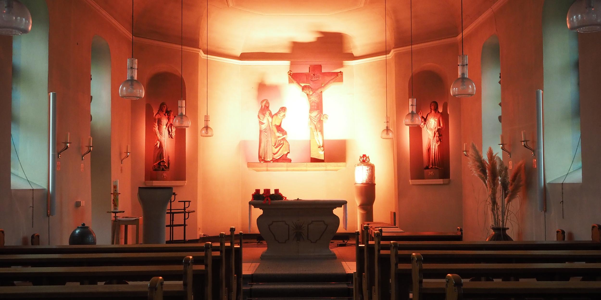 Blick in den gesamten Kirchraum, Altarraum in helles Licht getaucht.