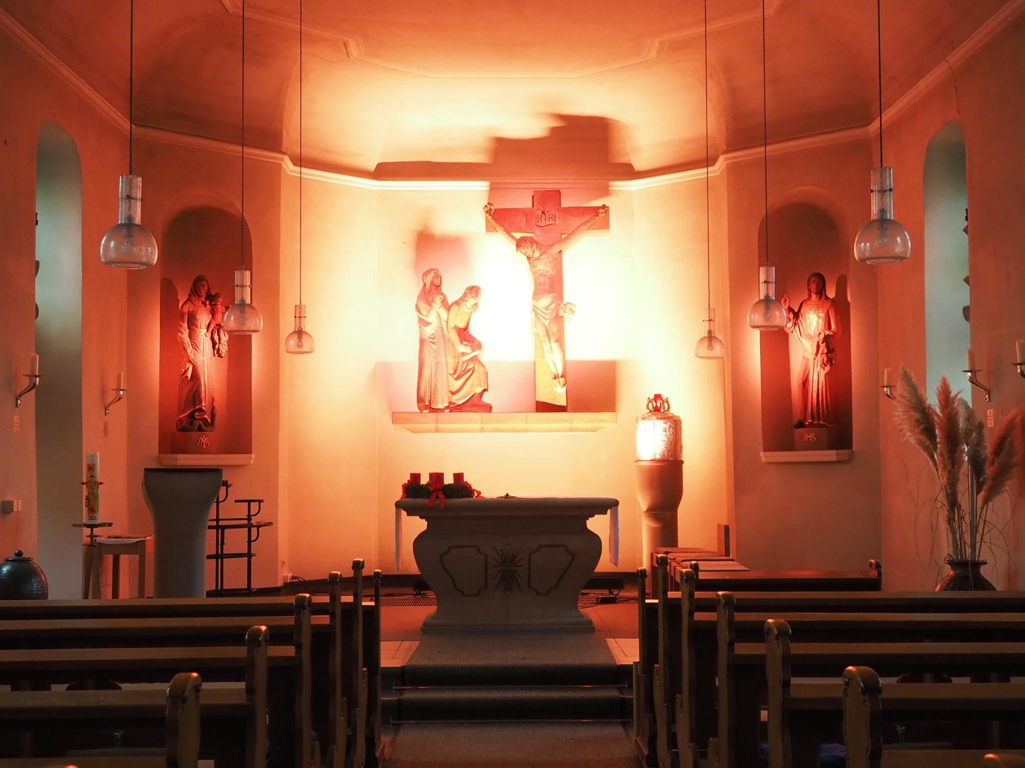 Blick in den gesamten Kirchraum, Altarraum in helles Licht getaucht.