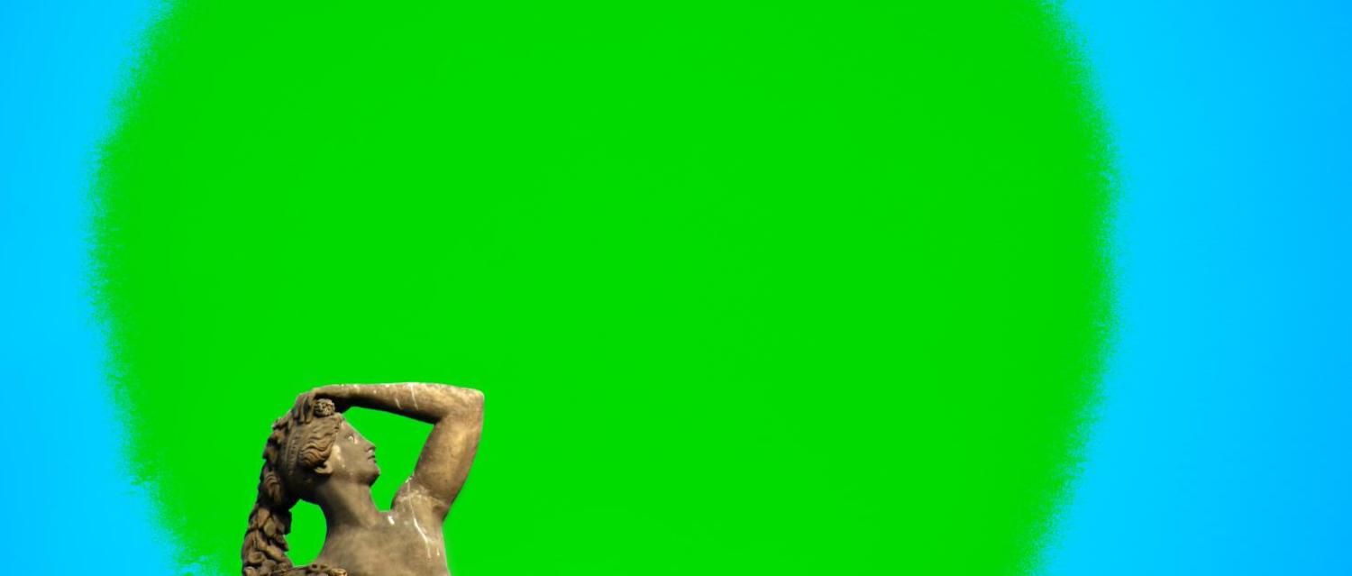 vor einem grünen Kreis steht eine Frauenstatue, die sich den Kopf hält