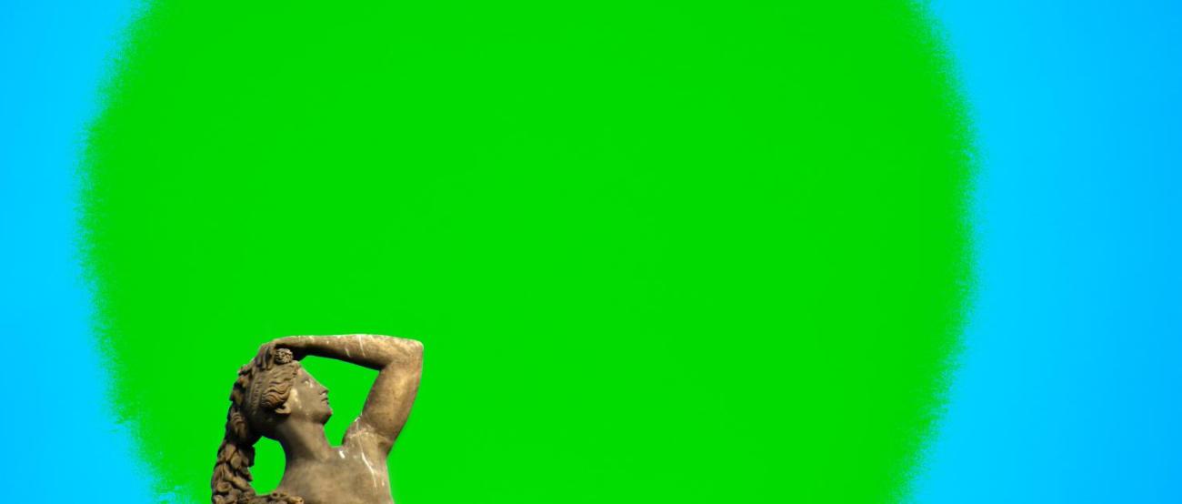 vor einem grünen Kreis steht eine Frauenstatue, die sich den Kopf hält