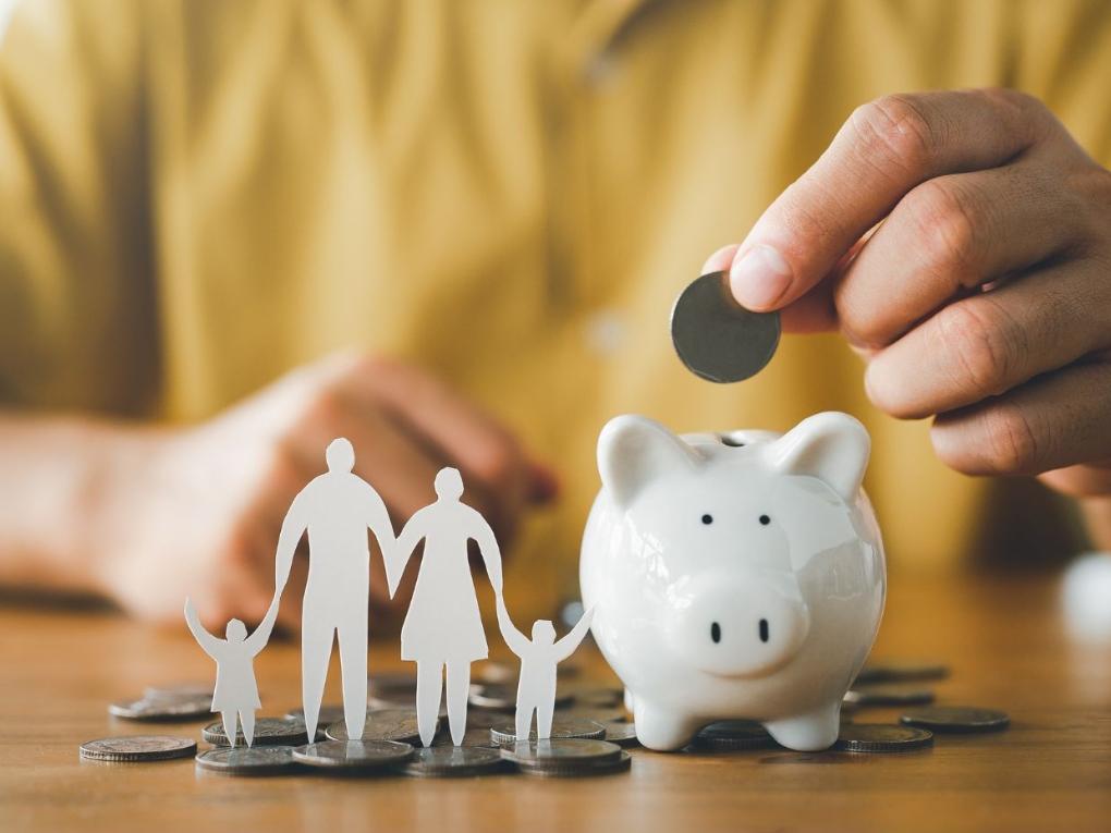 Sparschwein, in das eine Münze eingeworfen wird