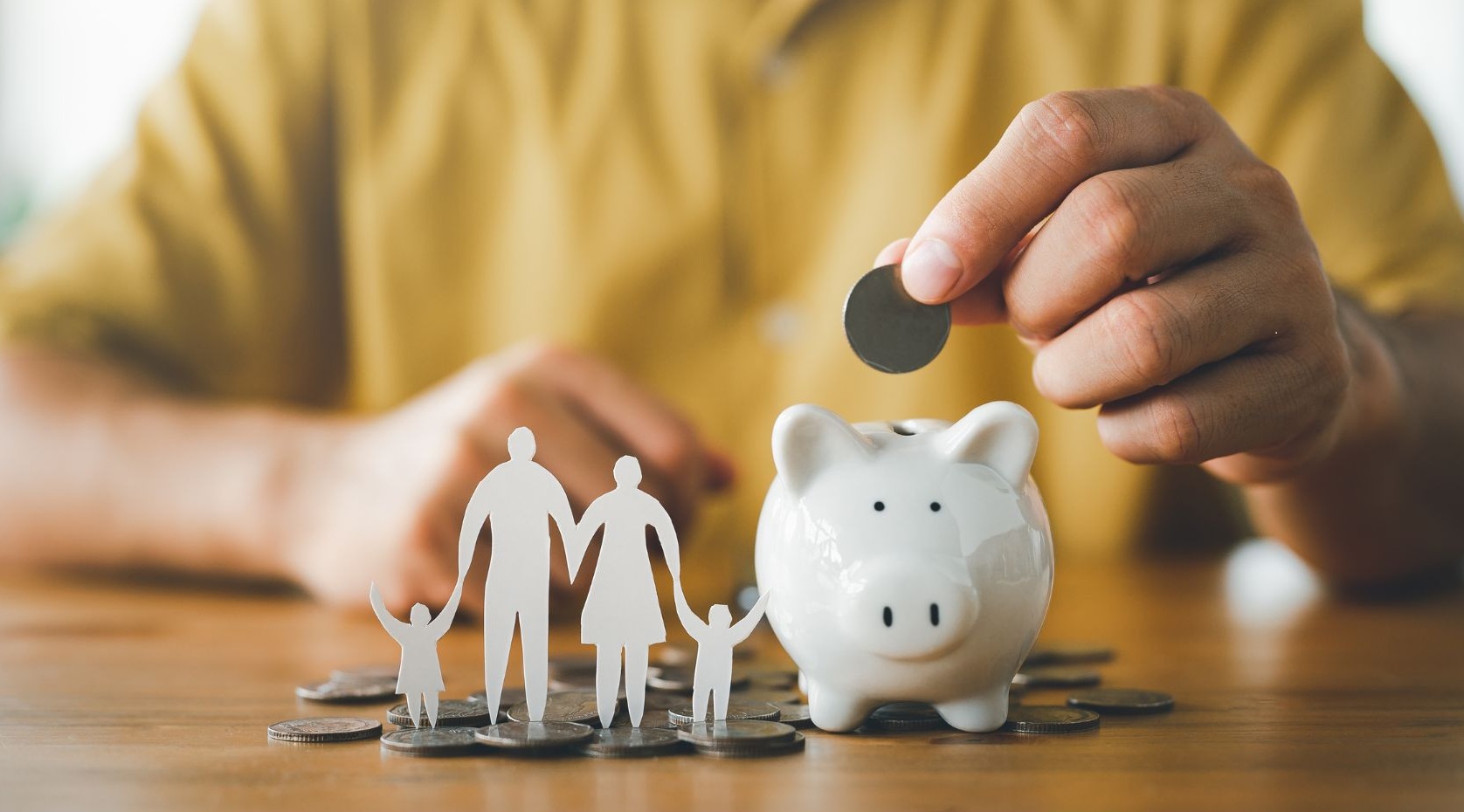 Sparschwein, in das eine Münze eingeworfen wird