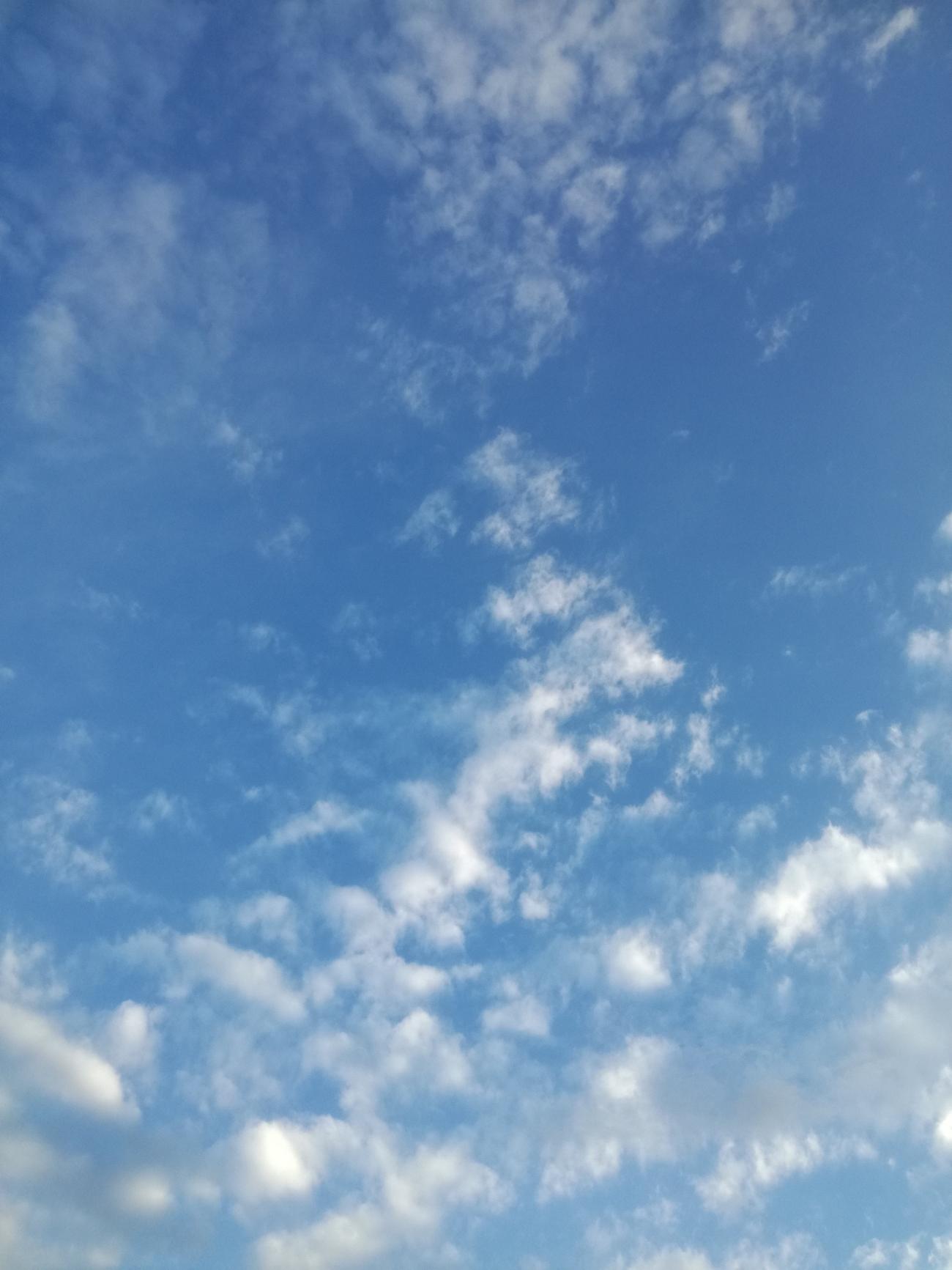 Blauer Himmel mit verstreuten weißen Wolken.