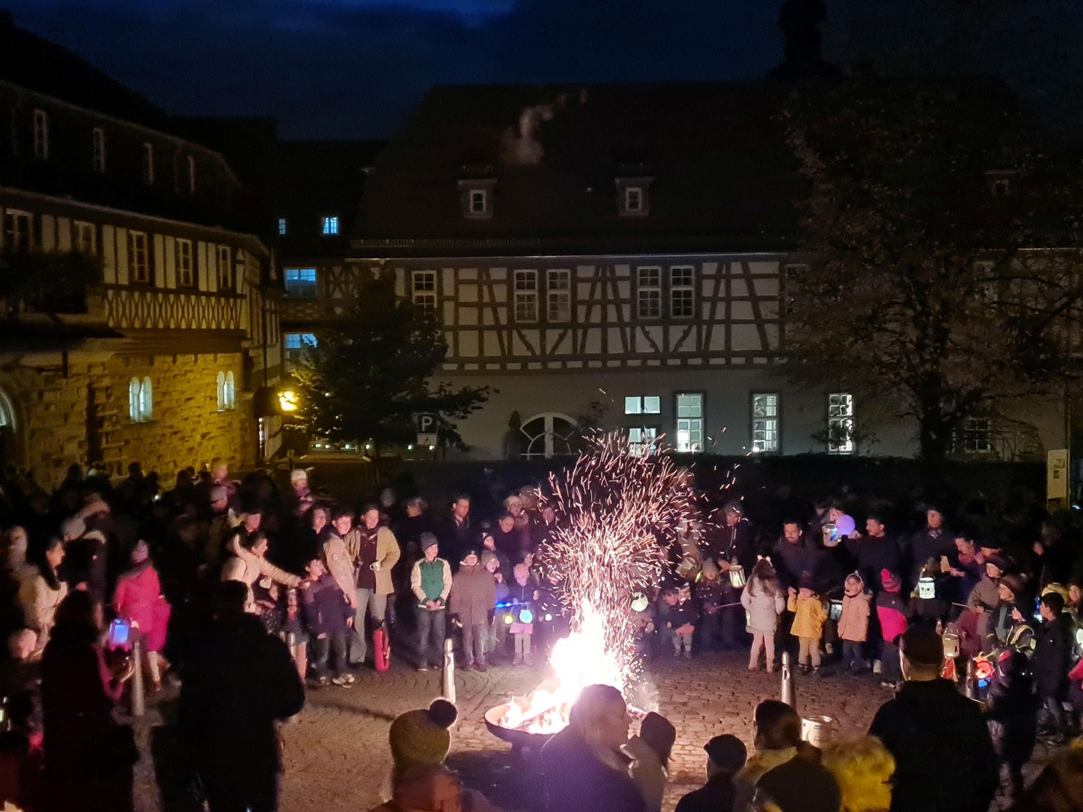 Sankt-Martin-Feier in Hl. Marianne Cope Heppenheim 2023 - Gruppe steht um das Feuer herum