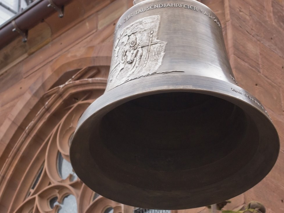 Glocke vor einem Fenster der Pfarrkirche St. Peter in Heppenheim
