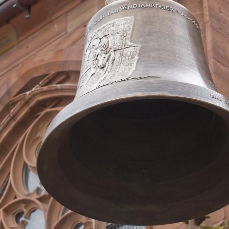 Glocke vor einem Fenster der Pfarrkirche St. Peter in Heppenheim