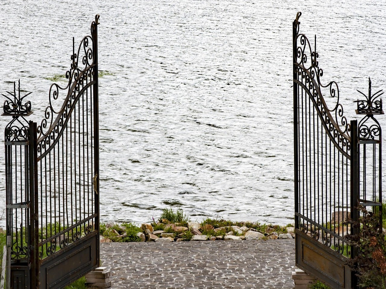 Gittertorflügel geöffnet am Fluss