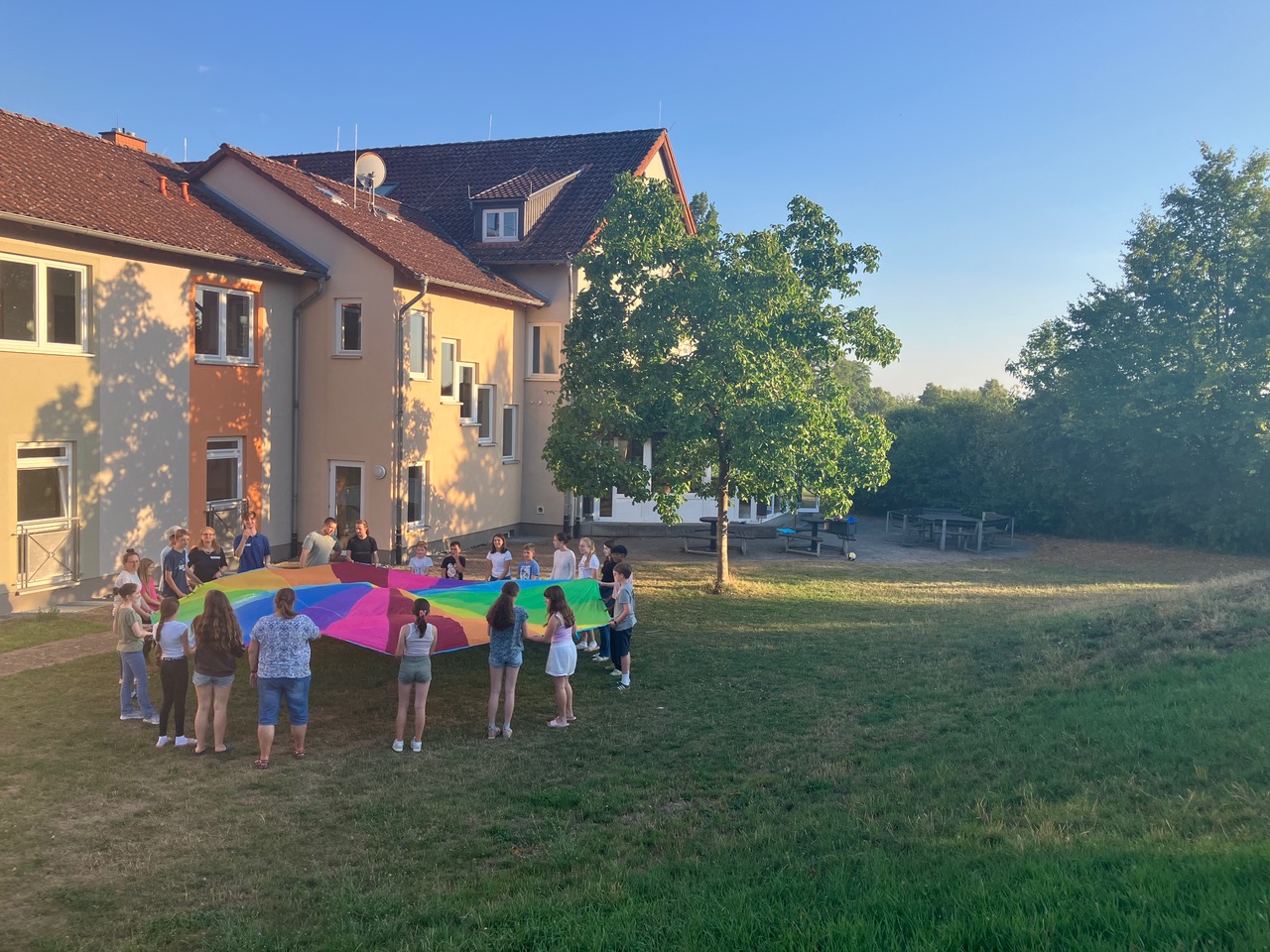 Kinder auf der Wiese vor dem Jugendhaus