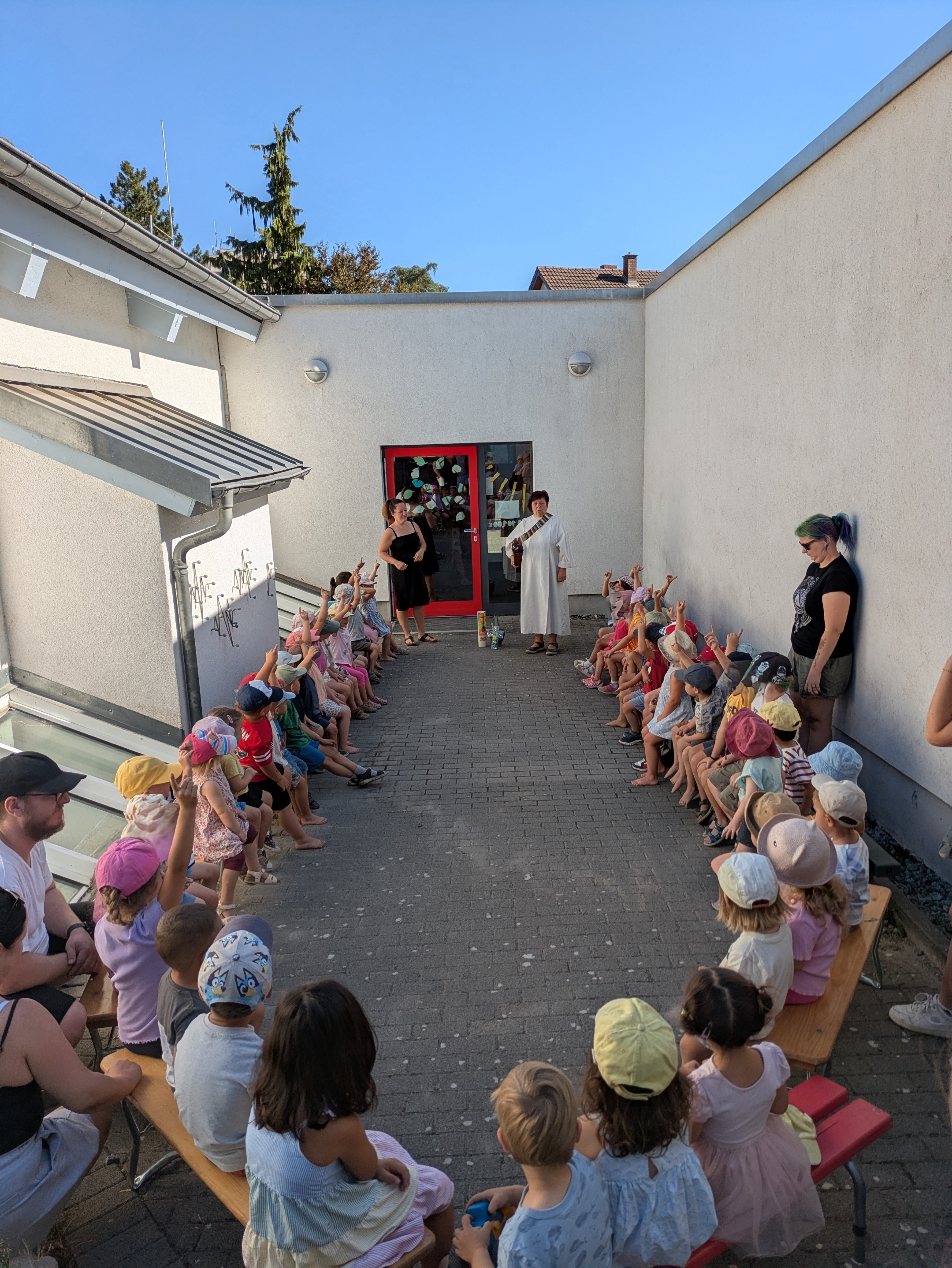 Die Kinder sitzen kreisförmig im Hof