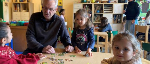 Sprachpate Wolfgang Knapp puzzelt mit Kindern in der Wichtelgruppe