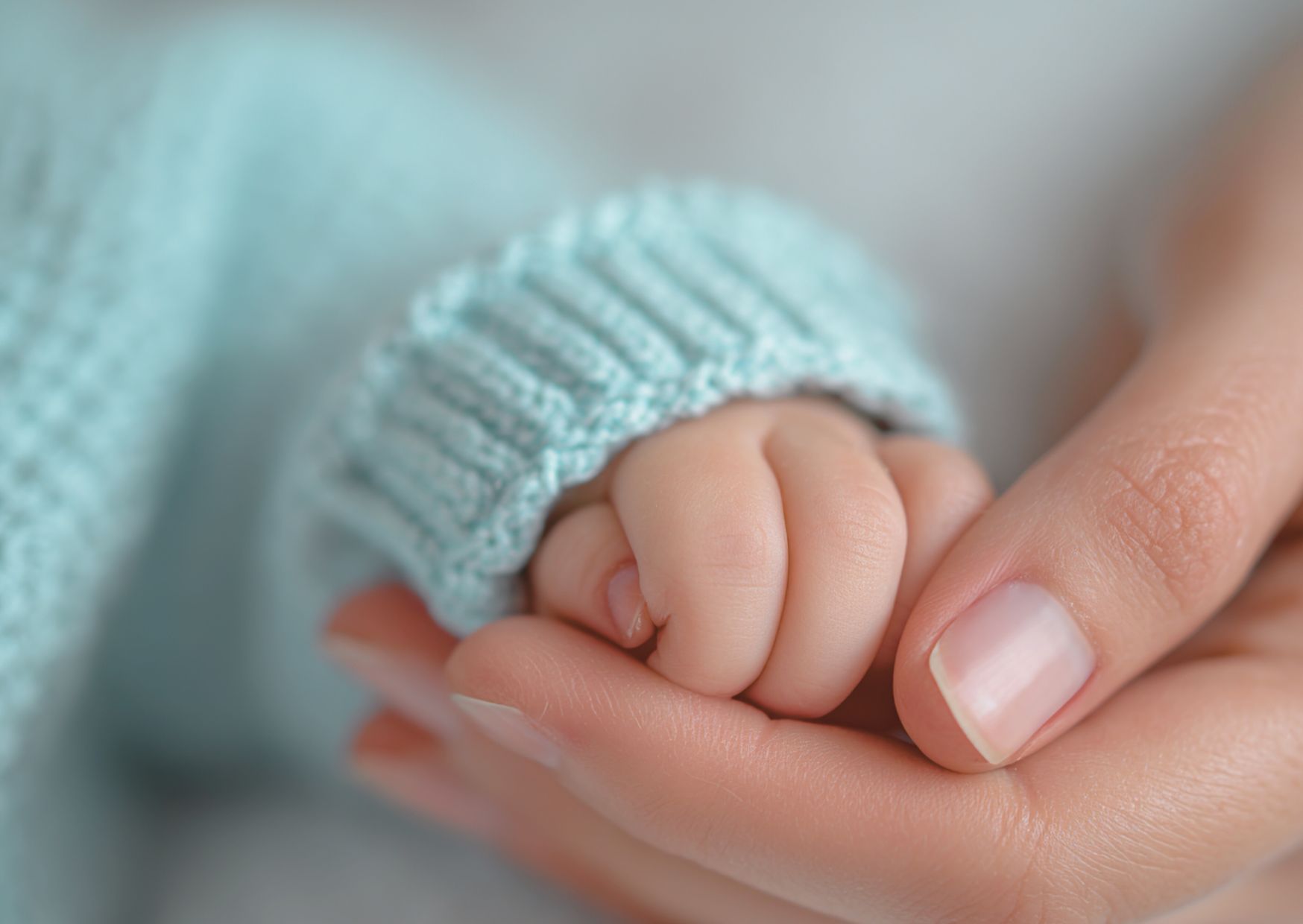 Eine kleine Hand wird von einer großen Hand gehalten