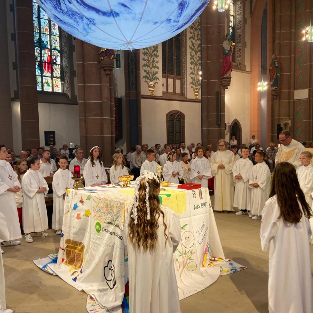 Die Kommuionkinder empfangen den Leib Christi.