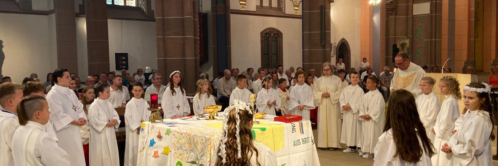 Die Kommuionkinder empfangen den Leib Christi.
