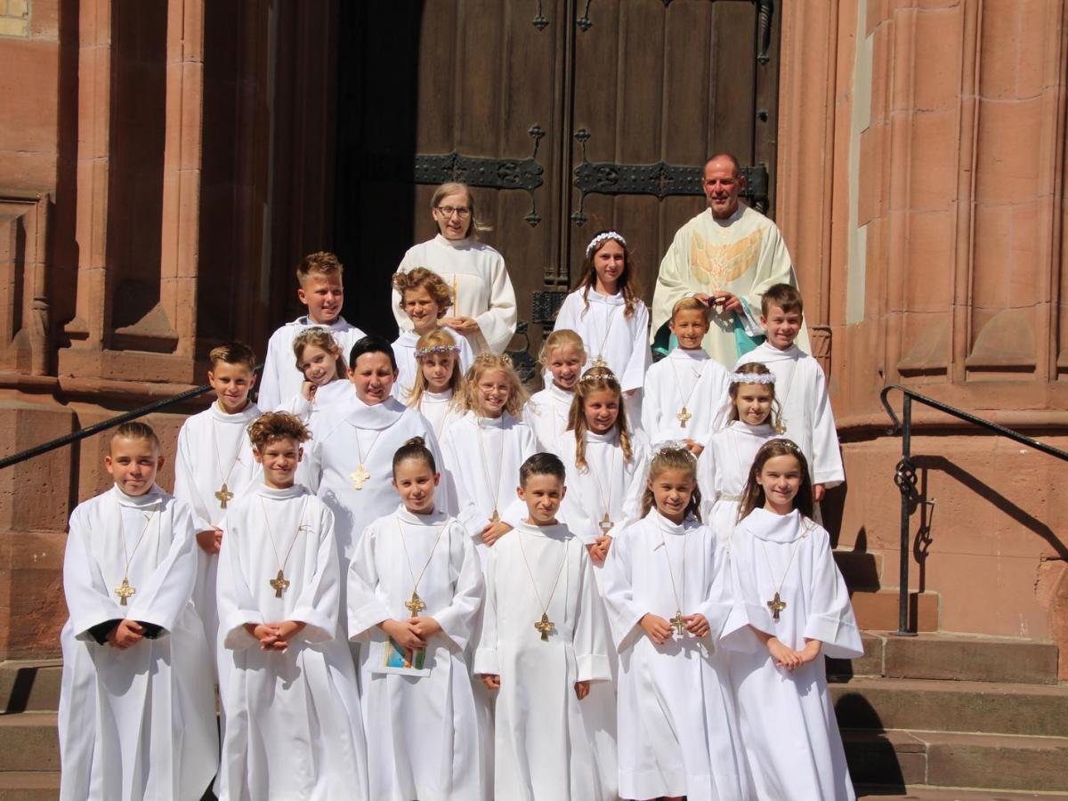 Die Kommunionkinder stehen auf den Stufen vor dem Hauptportal der Kirche.