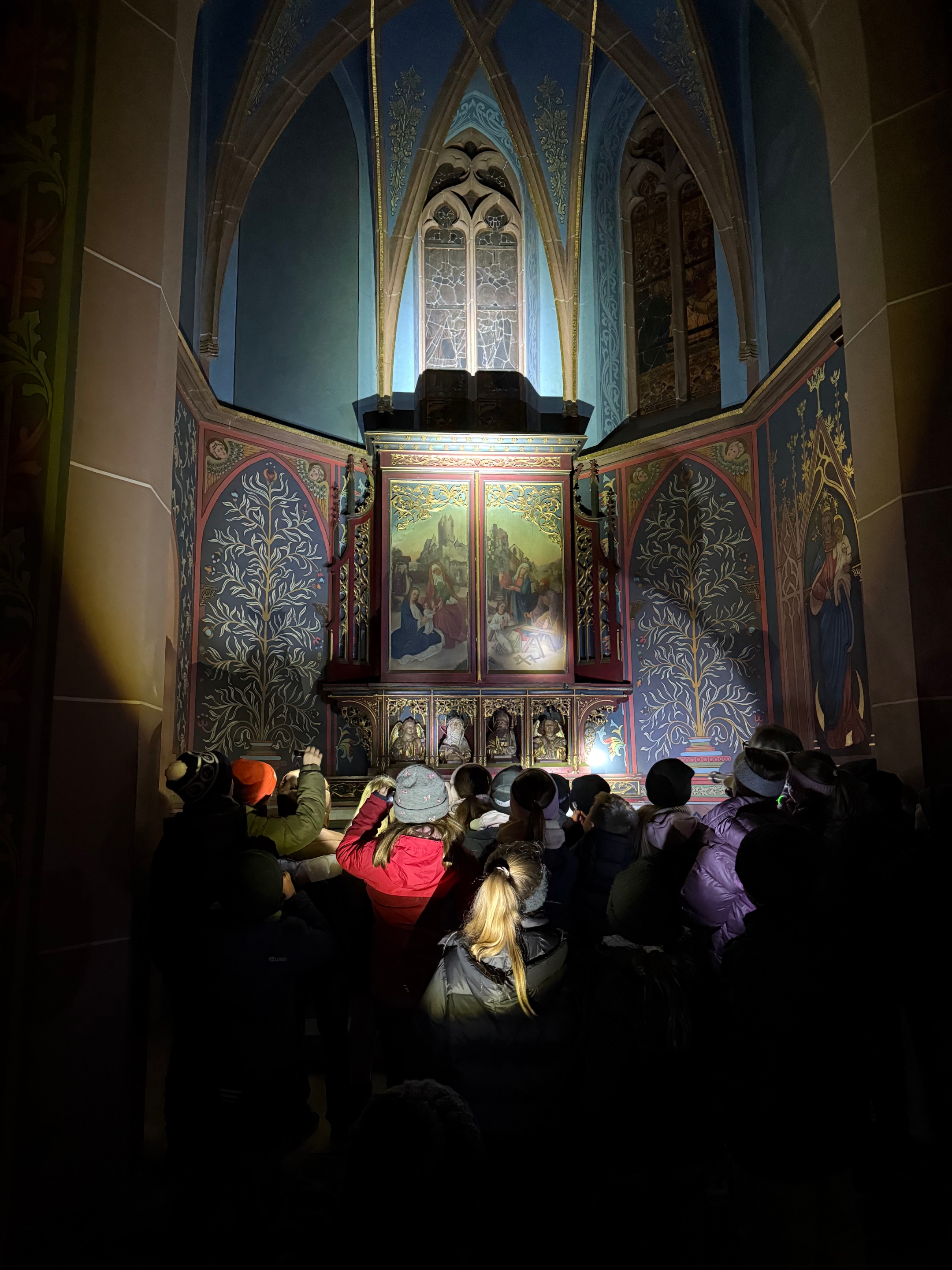 Mit Taschenlampen entdecken die Kommunionkinder die Apostelkirche.