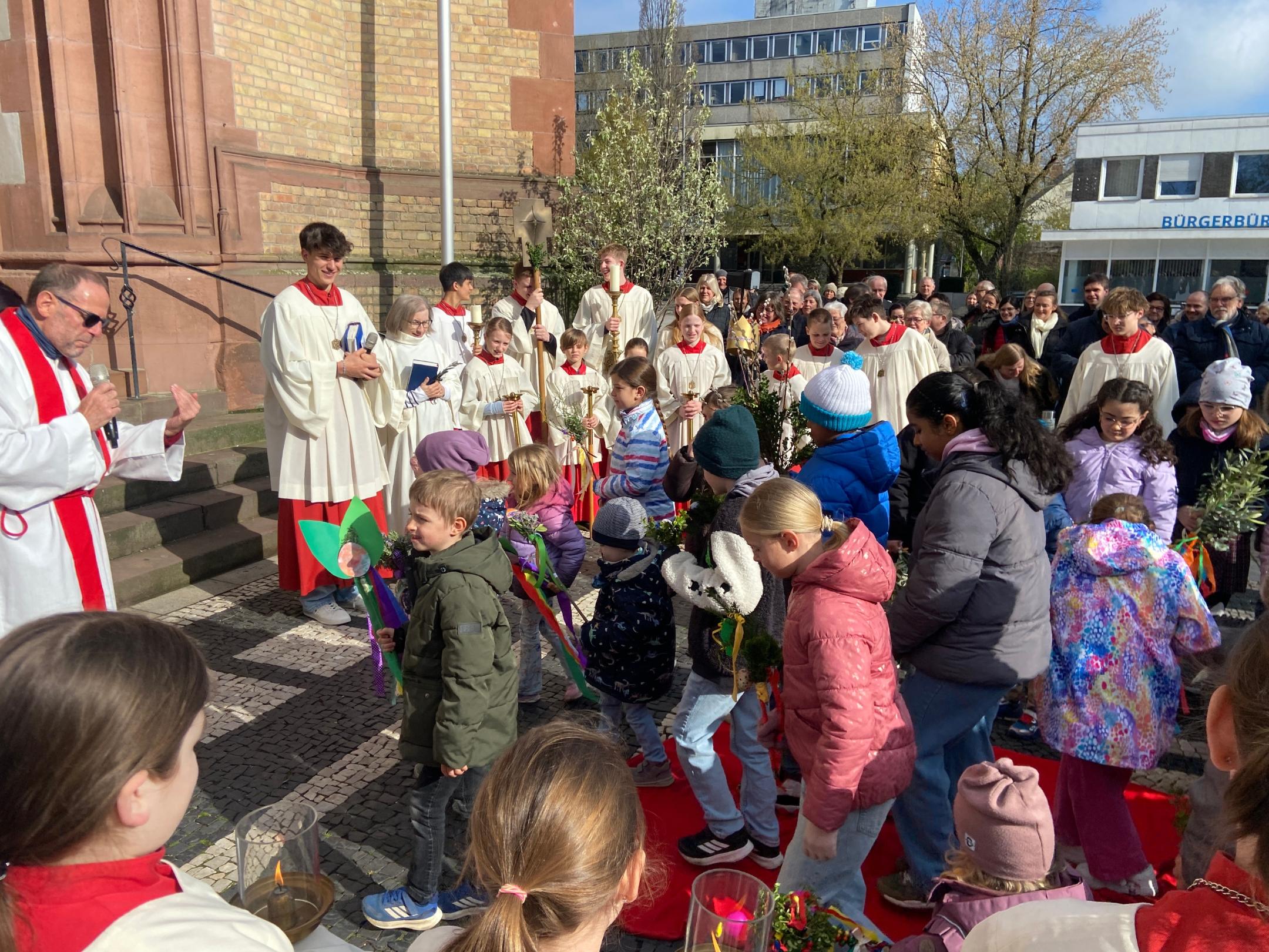 Mit vorsichtigen Schritten laufen die Kinder über das rote Gewand.