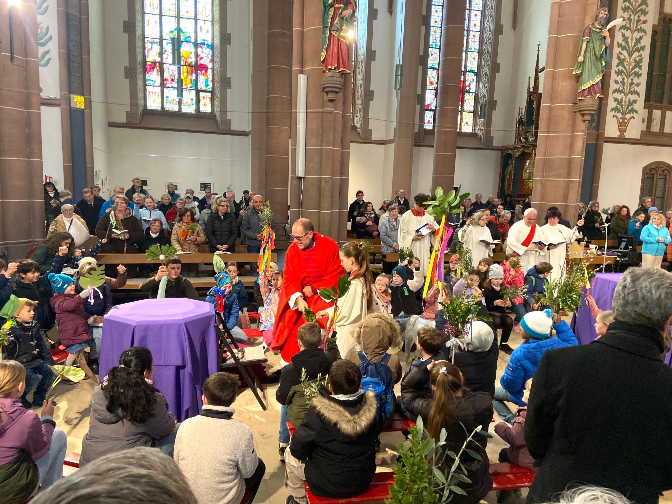 Mit den Eltern haben die Kinder Palmstecken gebastelt, die gesegnet werden.