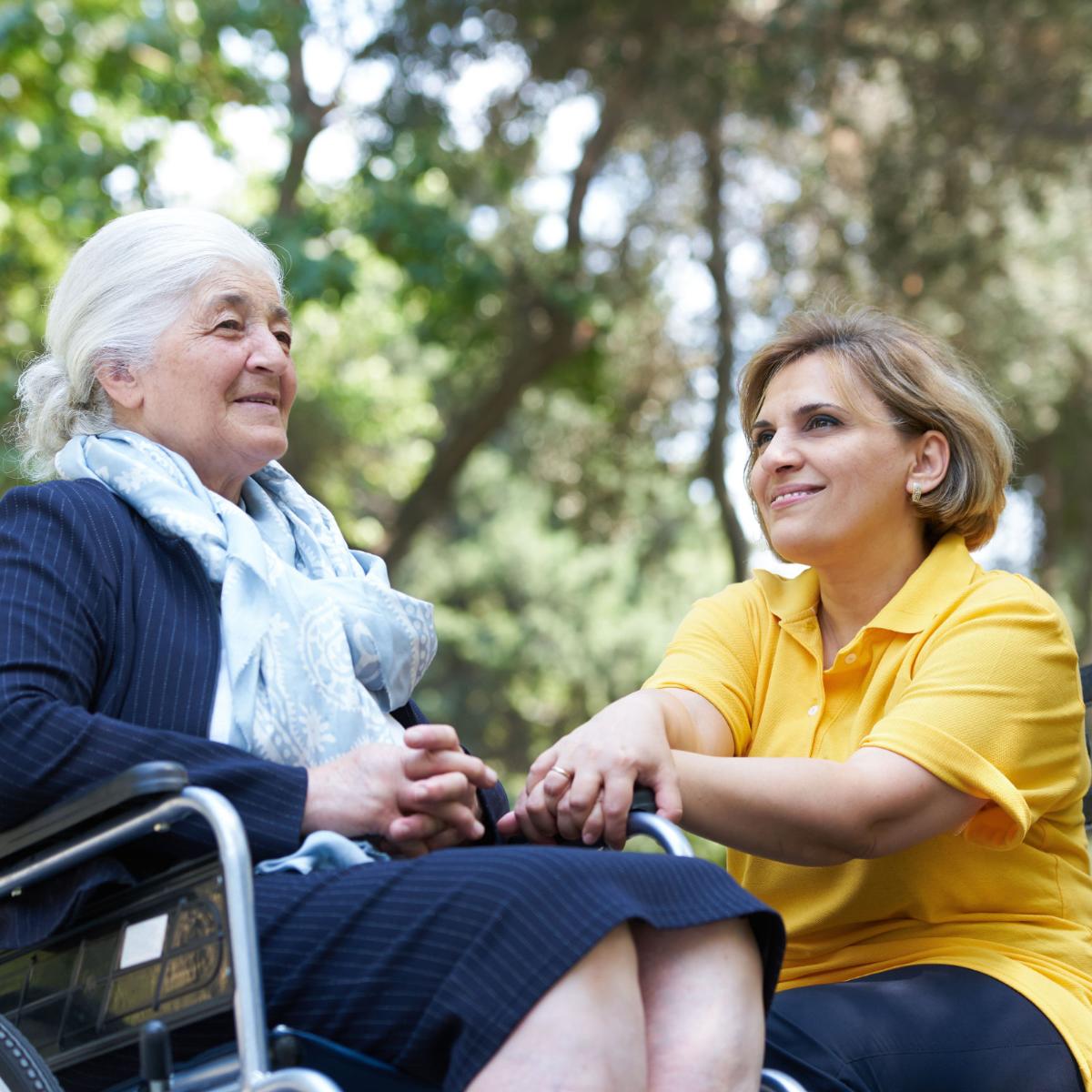 Frau mit alter Dame im Rollstuhl im Park