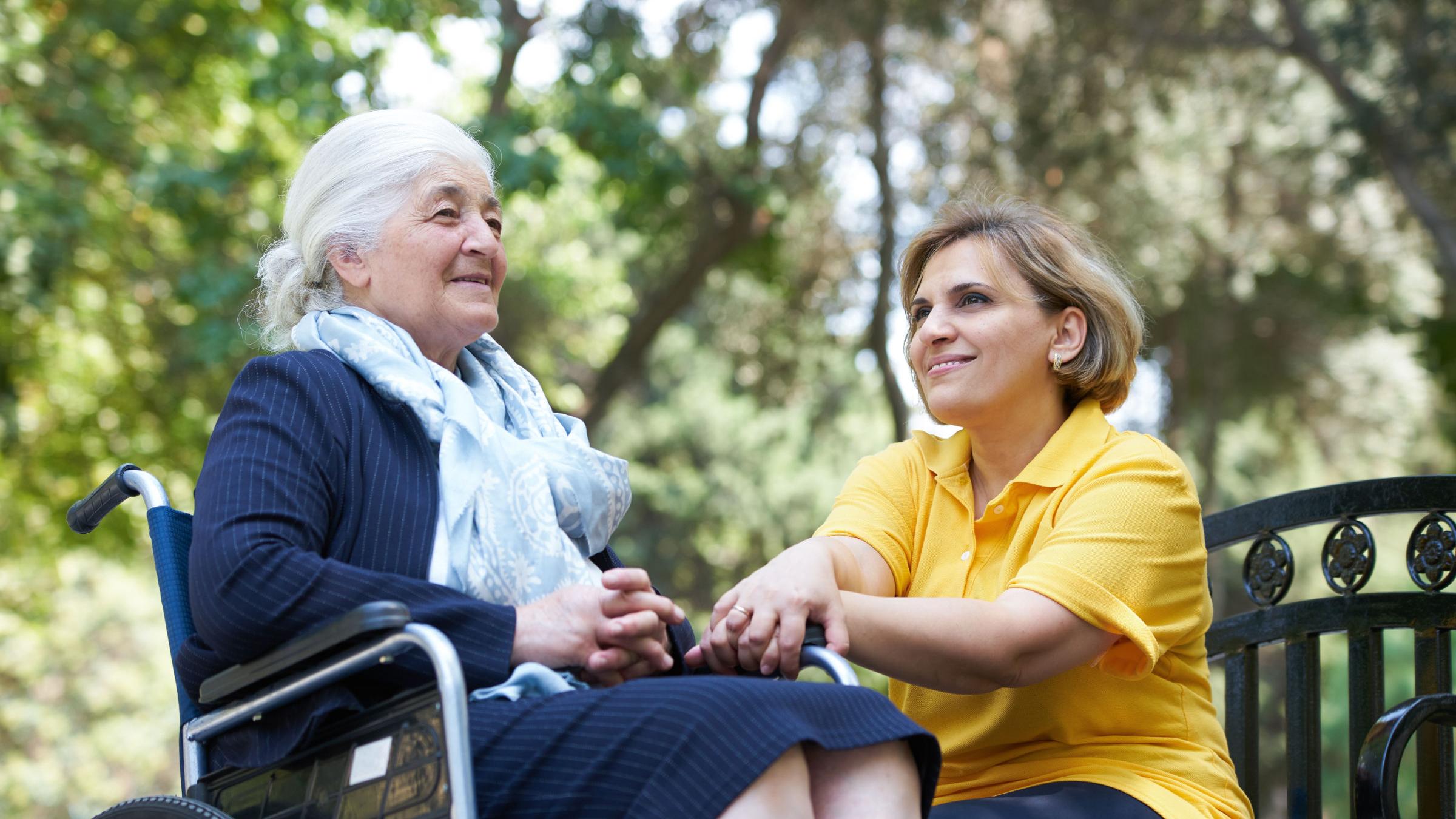 Frau mit alter Dame im Rollstuhl im Park